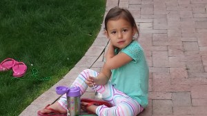 Jenna enjoys a break from Rainbow Looming to eat her dinner.