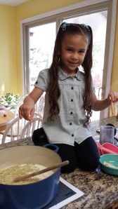 Mylee is tearing up the cheese for the soup.