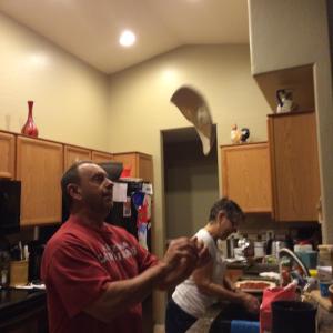 Dave shows he's got skillz by tossing the pizza in the air as he readys it for the pan.